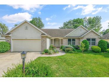 Charming single-story home with a well-manicured lawn, flowerbeds, and attached garage, providing curb appeal at 2402 Redspire Blvd, Goshen, IN 46526