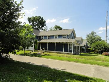 Charming home with inviting porch and well-maintained landscaping on a sunny day at 2502 N Harding St, Indianapolis, IN 46208