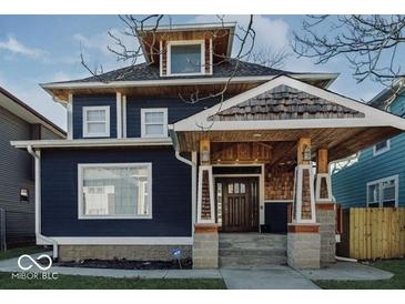 Beautiful two story home features a dark blue exterior, stone accents, covered porch, and well-maintained landscaping at 3054 Ruckle St, Indianapolis, IN 46205