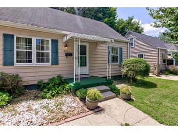 Charming home's front porch with green trim, white awning, and landscaped garden beds at 315 W 43Rd St, Indianapolis, IN 46208