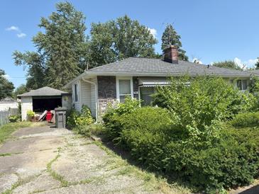 Charming ranch home with stone accents, mature trees, and a detached garage at 3709 N Layman Ave, Indianapolis, IN 46218
