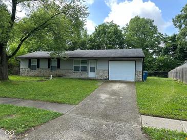 Charming single-story home with stone accents, an attached garage, and a well-maintained lawn at 4405 Phoenix Dr, Indianapolis, IN 46241