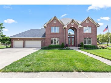 Stunning two-story brick home featuring a three-car garage and well-manicured front lawn at 4465 W Woodbridge Ln, New Palestine, IN 46163
