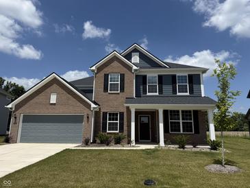Charming two-story home featuring a brick and siding exterior with a well-manicured lawn at 614 Corbin Way, Avon, IN 46123