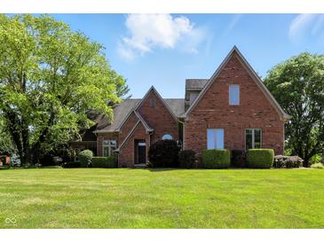 Charming brick home featuring well-maintained lawn and mature trees, offering a serene outdoor setting at 6183 Whitetail Run, Greenwood, IN 46143