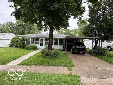 Charming single-story home featuring a covered carport and mature landscaping at 7918 Bonita Ct, Indianapolis, IN 46219