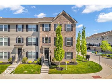 Charming brick and siding townhouse with a well-manicured lawn and inviting front entrance on a beautiful, sunny day at 3546 Brampton Ln, Westfield, IN 46074