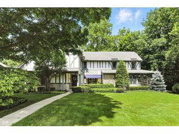 Beautiful home featuring a well-manicured front lawn, mature trees, and charming curb appeal at 380 Raintree Dr, Zionsville, IN 46077