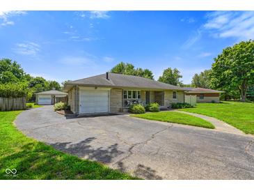 Charming single-story home featuring a stone facade, attached garage, and spacious circular driveway at 45 Kirk E Dr, Indianapolis, IN 46234