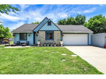 Charming home with stone accents, blue siding, inviting front yard, and a two-car garage at 5821 Pemberly Dr, Indianapolis, IN 46221