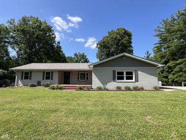 Charming single-story home featuring a well-maintained lawn, brick accents, and a welcoming front porch at 6238 E Southport Rd, Indianapolis, IN 46237