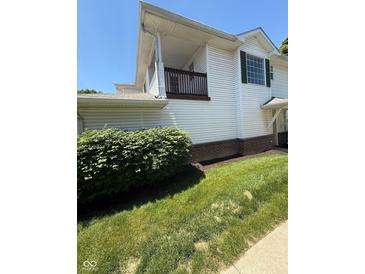 Two-story home featuring white siding, a small wooden porch, and manicured greenery, blending charm with curb appeal at 6504 Potomac Square Ln, Indianapolis, IN 46268