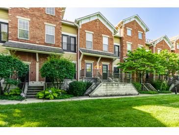 Attractive brick townhouse with a well-manicured lawn and lush landscaping at 6592 Reserve Dr, Indianapolis, IN 46220