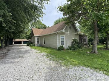A charming house shows its exterior with a gravel driveway, a quaint porch, and a well-maintained lawn at 6895 N County Road 625 E, Brownsburg, IN 46112