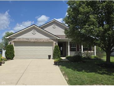 Charming home showcasing a well-manicured lawn, complemented by a spacious two-car garage at 7608 Mather Ln, Indianapolis, IN 46239