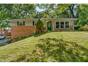 Charming brick home with well-manicured lawn and inviting front porch at 1302 N Furman Ave, Indianapolis, IN 46214