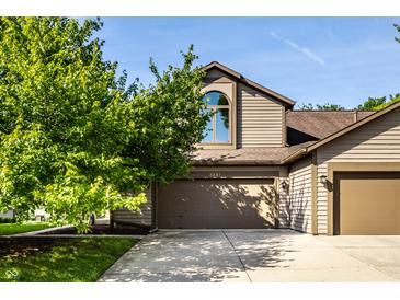 Charming two-story home with a well-manicured lawn and an attached two-car garage at 2247 Frisco Pl, Indianapolis, IN 46240