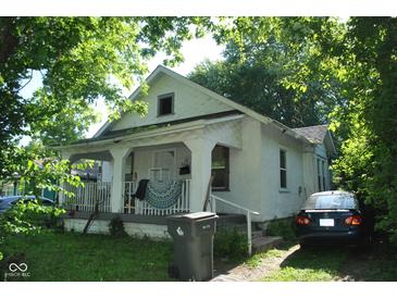 Charming two-story home with a covered porch and lush greenery surrounding the property at 3443 N Chester Ave, Indianapolis, IN 46218