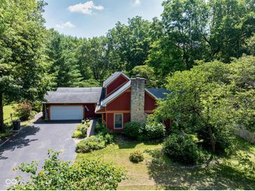 Charming two-story home with a stone chimney, attached garage, and professionally landscaped yard at 5631 Shelby St, Indianapolis, IN 46227