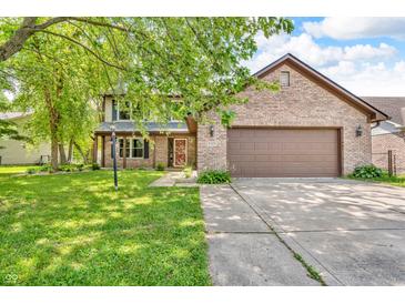 Charming two-story brick home featuring an attached two car garage and lovely front lawn at 6329 Whitaker Farms Dr, Indianapolis, IN 46237