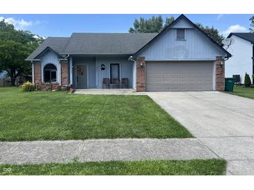 Charming one-story home with a well-manicured lawn, attached garage, and inviting front porch at 6932 Deerbrook Ct, Indianapolis, IN 46214