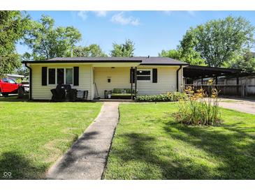 Charming single-story home with a well-maintained lawn, covered parking, and inviting front porch at 7307 Twin Beech Dr, Indianapolis, IN 46226