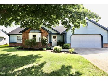 Charming, single-story home with blue siding, brick accents, well-maintained landscaping, and an attached garage at 7567 Muirfield Pl, Indianapolis, IN 46237