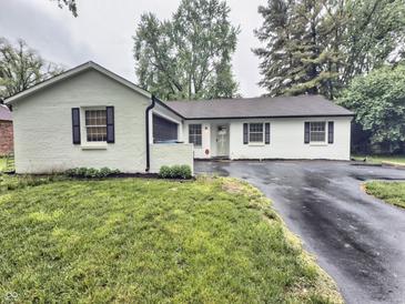 Charming single-story home with a freshly painted white exterior and inviting curb appeal in a well-maintained yard at 7719 Grandview Dr, Indianapolis, IN 46260