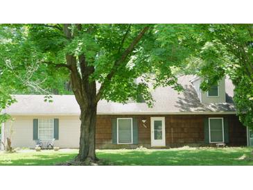 Charming ranch-style home featuring a well-manicured lawn and mature trees providing shade at 7966 Chiltern Dr, Indianapolis, IN 46268