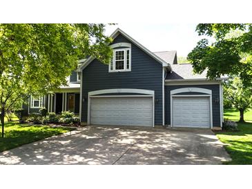 Charming two-story home with a two-car garage and lush landscaping, complete with mature trees at 8394 Glen Highlands Dr, Indianapolis, IN 46236