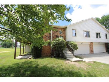 Charming townhome featuring brick and siding, complemented by a well-maintained lawn and mature trees at 9323 Doubloon Rd, Indianapolis, IN 46268