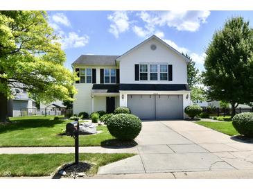 Charming two-story home with a well-manicured lawn and mature trees at 10539 Ross Xing, Fishers, IN 46038