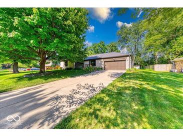 Charming ranch home with a spacious front yard, large tree, and an attached two-car garage at 11 N Restin Rd, Greenwood, IN 46142
