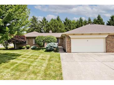 Charming brick home with manicured lawn, mature trees, and attached garage. The home's number is visible above the garage at 13 Marywood Dr, Greenfield, IN 46140