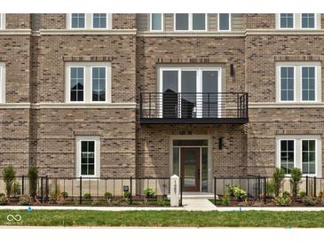 Charming brick townhome featuring a balcony, stylish windows, and a landscaped front yard with a welcoming entrance at 1461 Whistle Way, Westfield, IN 46074