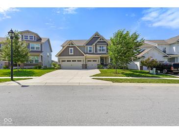 Charming two-story home with three-car garage and landscaped yard on a sunny day at 15813 Arthur Jacob Ln, Noblesville, IN 46060