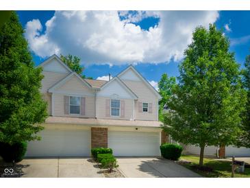 Charming townhouse with a two-car garage, lovely landscaping and inviting curb appeal on a beautiful, sunny day at 1856 Misty Lake Dr, Indianapolis, IN 46260