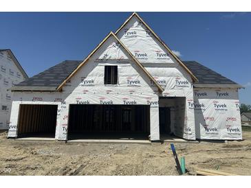 New construction home featuring Tyvek home wrap, an attached garage, and a newly installed roof in a suburban neighborhood at 19990 Stone Side Dr, Westfield, IN 46074