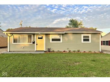 Charming single-story home with a well-manicured lawn and a bright yellow front door at 2563 Harlan St, Indianapolis, IN 46203