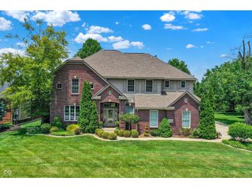 Beautiful brick home with manicured lawn, mature trees, and lush landscaping at 4704 Pearcrest Way, Greenwood, IN 46143