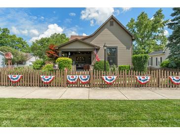 Charming home with a quaint front yard, decorative fence, and inviting curb appeal under a sunny sky at 718 E Washington St, Lebanon, IN 46052