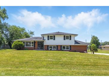 Charming two-story home with a well-maintained lawn and classic curb appeal on a sunny day at 1011 Robin Dr, Anderson, IN 46013