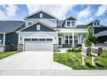 Beautiful two-story home featuring manicured lawn, neutral paint, attached two-car garage, and charming curb appeal at 14404 Stairbridge Pl, Carmel, IN 46074