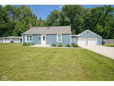 Charming blue home with a well-maintained lawn and a detached two-car garage at 5902 Oak Ln, Anderson, IN 46013
