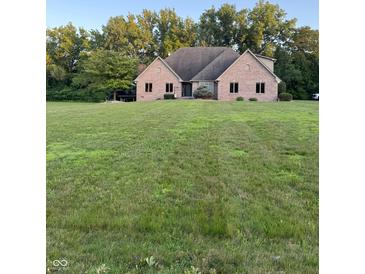 Lovely brick home featuring a sprawling green lawn and mature trees creating a serene and private setting at 5993 E County Road 100 S, Avon, IN 46123