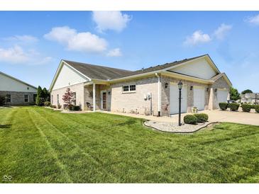 Charming brick home featuring an attached three-car garage and well-maintained lawn at 712 Disciples Way, Greenwood, IN 46143