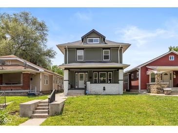 Charming two-story home featuring a covered front porch and well-maintained landscaping at 1141 W 35Th St, Indianapolis, IN 46208