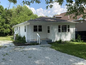 Charming single-story home with gravel driveway and a cozy front porch, perfect for relaxing outdoors at 1605 S Leland Ave, Indianapolis, IN 46203