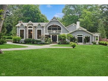 Charming home featuring lush lawn, manicured landscaping, stone accents, and architectural details at 1805 Wood Valley Dr, Carmel, IN 46032