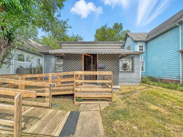 Charming home featuring accessible wooden ramp leading to lattice-covered porch at 405 Harlan St, Indianapolis, IN 46201